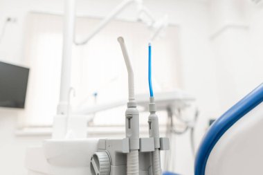 Yakın plan dişçi tükürüğü fırlatıcısı. Klinikte dişçilik. Ameliyat, diş protezi. Tıp, sağlık, stomatoloji konsepti. Diş hekiminin teftiş yaptığı ve sonuca vardığı ofis..