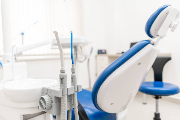 Close-up dentist saliva ejector. Dental work in clinic. Operation, tooth replacement. Medicine, health, stomatology concept. Office where dentist conducts inspection and concludes.