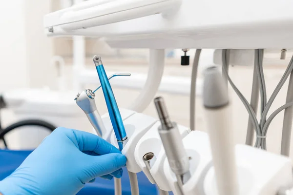 Close-up hand of dentist in the glove holds dental high speed turbine. Office where dentist conducts inspection and concludes. — Stock Photo, Image