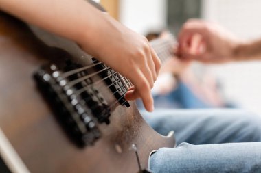 Genç beyaz adam elini ipler boyunca hareket ettirir. Bir müzik aleti çalmayı öğrenme kavramı