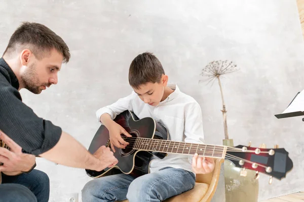 Bambino imparare a suonare la chitarra mentre il fratello maggiore guarda a lui — Foto Stock