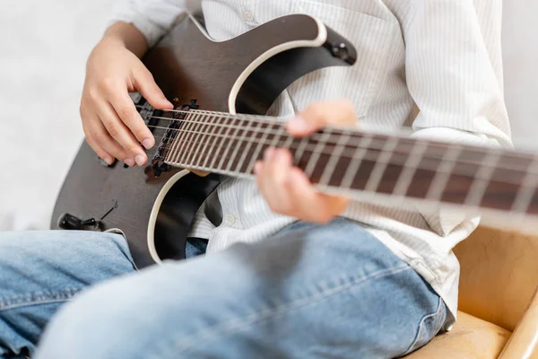 Electric guitar laying in hands of european male in casual clothes