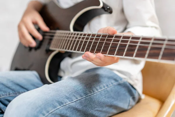 Primo piano della chitarra elettrica nelle mani del ragazzo in abiti casual — Foto Stock