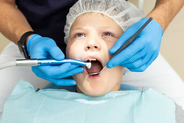 Petit garçon est allongé sur une chaise de dentiste et a obtenu ses dents percées par un stomatologue professionnel — Photo