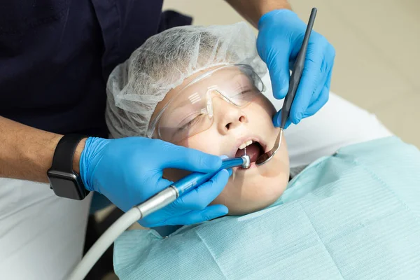 Stomatologo denti di perforazione del paziente che si trova sulla sedia del dentista — Foto Stock