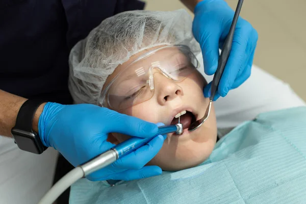 Stomatologo denti di perforazione del paziente che si trova sulla sedia del dentista — Foto Stock