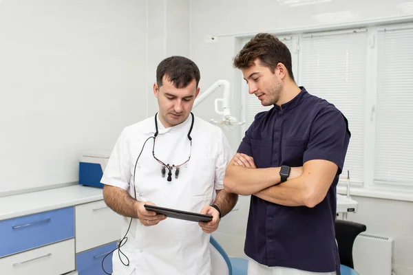Two hospital workers examinig resoults of patients analyses together
