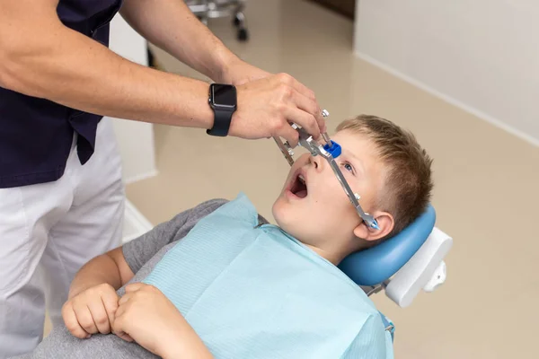 Dokter bereidt zijn patiënt voor op het opknappen van orthodontische boog — Stockfoto
