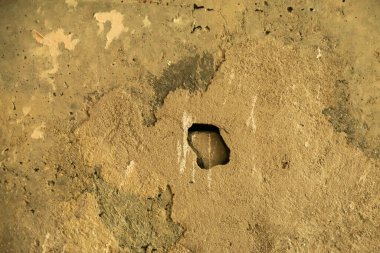 Delikli eski beton bir duvar.