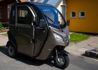 Evin önüne park edilmiş küçük elektrikli bir araç, Bornholm.