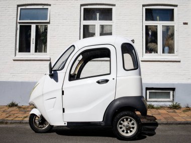Beyaz Saray arka planında küçük beyaz elektrikli araba, Ronne, Bornholm