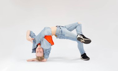 Zor bir dans pozisyonunda genç bir çocuk, kot giymiş bir sarışın, dansçı. 