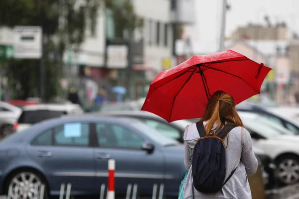 woman with umbrella under the rain in the street