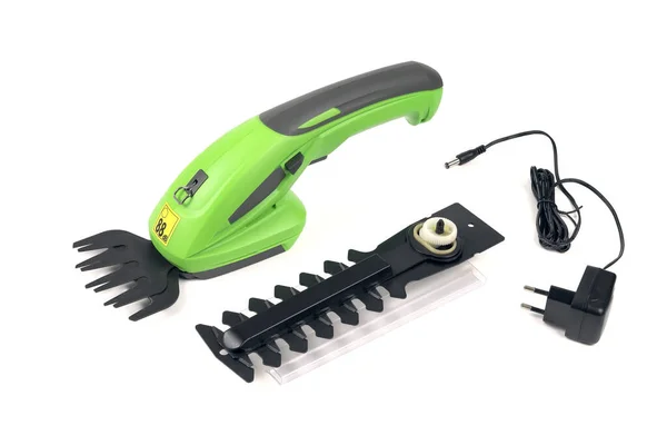 Electric rechargeable handheld trimmer for garden bush pruning, figurine home decoration, with an additional replaceable attachment and charger for powering the battery. Isolated on white background