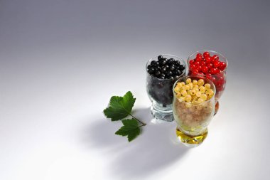 Yüzeyde üç farklı bardaktaki üzümler bir arada. Doğadan lezzetli ve sağlıklı yiyecekler. Kopyalama alanı olan Gradyan arkaplan