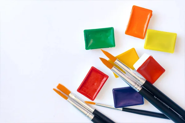 Foto de pincéis para pintura a cores de água de perto e conjunto de tintas de aquarela — Fotografia de Stock
