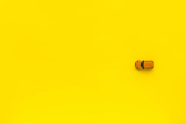 Pequeño coche de juguete amarillo sobre un fondo amarillo. Espacio libre para texto —  Fotos de Stock