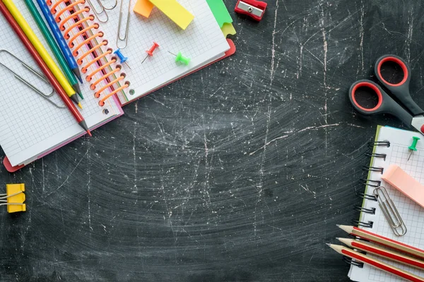 Iskola és irodai kellékek egy Chalkboard háttérben. Szabad hely a szöveghez. Felülnézet — Stock Fotó