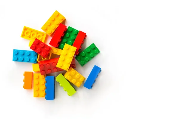 Bando de tijolos construtor Multicolor Plastick no fundo branco. Brinquedos populares. Espaço de cópia — Fotografia de Stock
