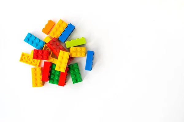 Ladrillos de construcción Plastick multicolor sobre fondo blanco. Juguetes populares. Espacio de copia —  Fotos de Stock