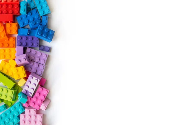Um monte de tijolos coloridos construtor Plastick no fundo branco. Brinquedos populares. Espaço de cópia — Fotografia de Stock