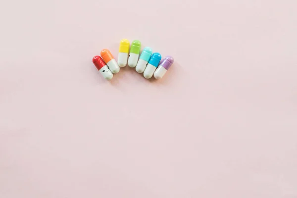 Legrační vícebarevné kapsle na pastelovém papíře. Copyspace — Stock fotografie