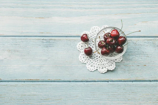 Rijpe rode zoete kersen op blauwe houten achtergrond. Platte lay stijl. Kleurrijk dieet en gezond voedsel concept. — Stockfoto