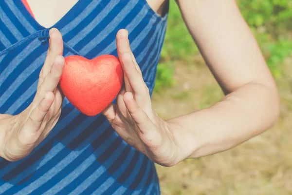 Relatie en liefde concept-dames handen houden van rood hart — Stockfoto