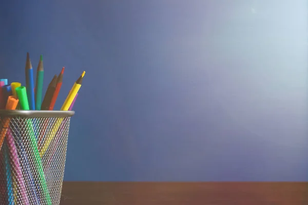 Colegiales y estudiantes estudian accesorios. De vuelta al concepto escolar. Lápices y rotuladores sobre fondo azul. Espacio de copia — Foto de Stock