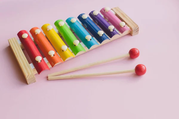 Regenbogenfarbenes Holzspielzeug-Xylophon auf rosa Speck. Spielzeug-Glockenspiel aus Metall und Holz — Stockfoto