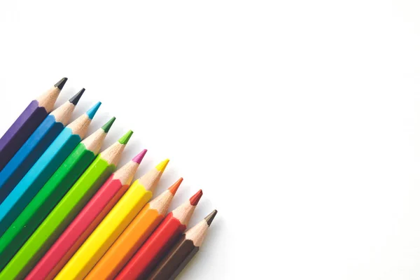 Ряды цветных карандашей на белом бумажном фоне, копировальное пространство. Офисные принадлежности, обратно в школу . — стоковое фото