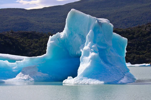 Μεγάλη μπλε φωτεινή παγόβουνα επιπλέουν πάνω στα νερά της λίμνης Lago Argentino, El Calafate, Αργεντινή στην ημέρα ηλιοφάνειας. — Φωτογραφία Αρχείου