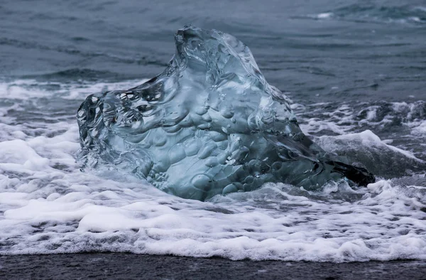 Csodálatos átlátszó kék jéghegy darabot a Diamond Beach fekete homok közelében Jokulsarlon lagúna, Izland. Jég ellés. Fekete-fehér kontraszt. — Stock Fotó