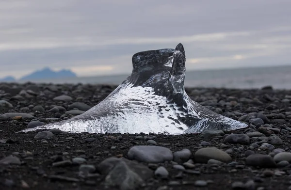 Increíbles piezas de iceberg azul transparente en la playa de Diamond con arena negra cerca de la laguna de Jokulsarlon, Islandia. Terneros de hielo. Contraste blanco y negro . — Foto de Stock