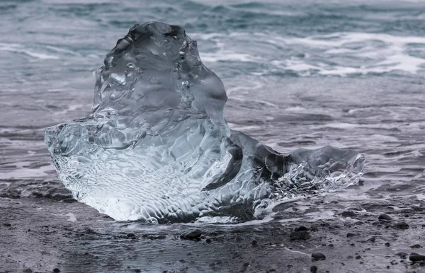 Amazing transparent blue iceberg pieces on Diamond beach with black sand near Jokulsarlon lagoon, Islândia. Parto de gelo. Contraste preto e branco . — Fotografia de Stock