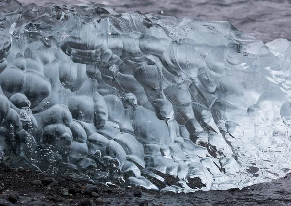 Increíbles piezas de iceberg azul transparente en la playa de Diamond con arena negra cerca de la laguna de Jokulsarlon, Islandia. Terneros de hielo. Contraste blanco y negro . — Foto de Stock