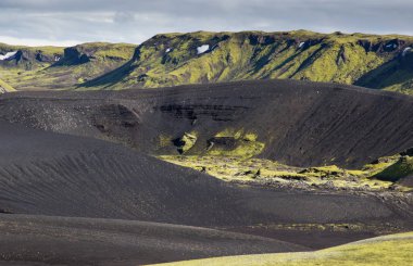 Yeşil bir tepe ve siyah lav ile dramatik İzlanda manzara bir ay gibi görünüyor. İzlanda Huzuru.