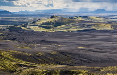 Yeşil bir tepe ve siyah lav ile dramatik İzlanda manzara bir ay gibi görünüyor. İzlanda Huzuru.
