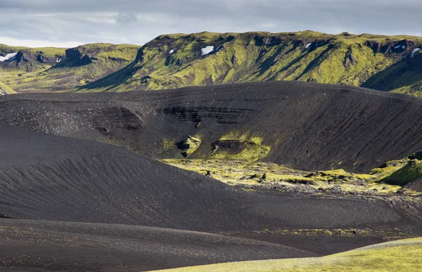 Die dramatische Eislandschaft mit einem grünen Hügel und schwarzer Lava sieht aus wie ein Mond. Gelassenheit der Isländer. — Stockfoto
