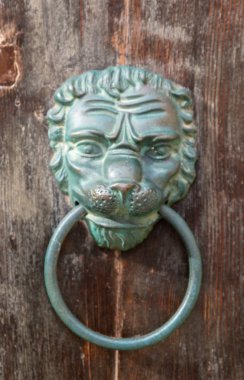 Ahşap bir kapı üzerinde eski paslı demir aslan baş kapı tokadı. Mdina, Malta