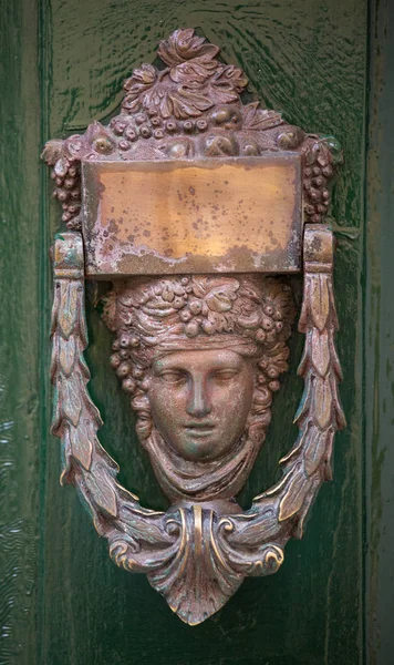 Decorative bronze door handle in the form of a beautiful womans head on a green painted door. Malta — Stock Photo, Image