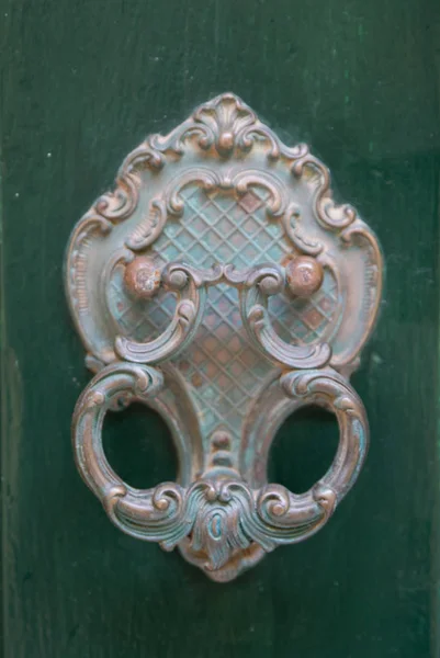 An old style decorative bronze door handle on a wooden green door, the distinctive feature and symbol of Malta in Mdina. — Stock Photo, Image