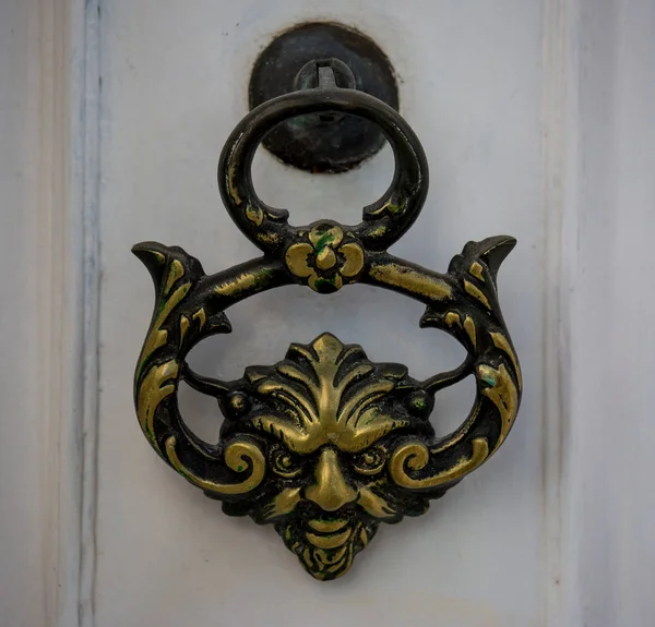 Ένα παλιό στυλ διακοσμητικό χάλκινο χερούλι της πόρτας σε μια ξύλινη πόρτα, το διακριτικό χαρακτηριστικό και το σύμβολο της Μάλτας στη Μντίνα. — Φωτογραφία Αρχείου