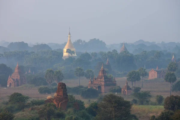 Orange mystischen Sonnenaufgang Landschaft Ansicht mit Silhouetten von alten antiken Tempeln und Palmen in der Morgendämmerung Nebel aus Ballon, Heiden, Myanmar. Burma — Stockfoto