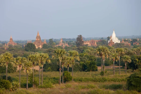 Vista mística laranja da paisagem do nascer do sol com silhuetas de antigos templos antigos e palmeiras no nevoeiro do amanhecer do balão, Bagan, Myanmar. Birmânia — Fotografia de Stock