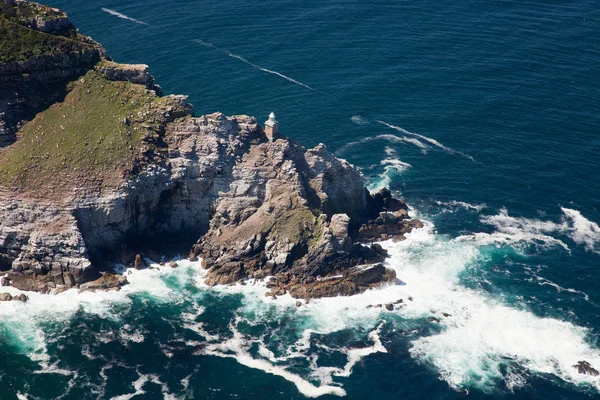 Aerial view of Cape point with lighthouse and Cape of Good Hope from a helicopter. Panorama of South Africa from birds eye view on a sunny day. Edge of the earth from helicopter view. — Stock Photo, Image