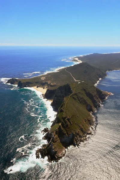 Aerial view of Cape point with lighthouse and Cape of Good Hope from a helicopter. Panorama of South Africa from birds eye view on a sunny day. Edge of the earth from helicopter view. — Stock Photo, Image