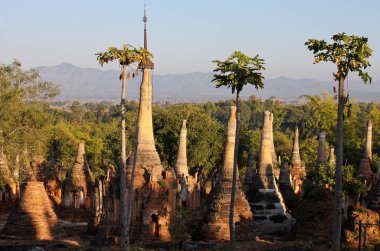 Shwe Inn Thein Paya, Indein, Nyaungshwe , Inle Lake,Shan state, Myanmar .Burma . Weather-beaten buddhistic pagodas and stupas in different destructive condition clipart
