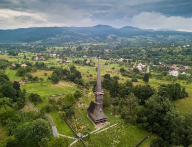 Avrupa'nın en yüksek ahşap çan kulesi ile Transilvanya geleneksel antik Maramures ahşap ortodoks kilisenin havadan panoramik görünümü, Romanya. UNESCO dünya mirası.