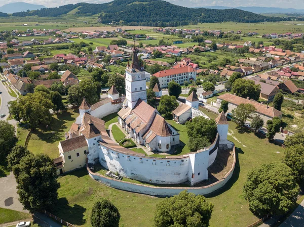 Az erődített templom nagy, vastag Erdélyi falakkal körülvett, szép nyári napon, a falura nyíló kilátással. Románia. — Stock Fotó